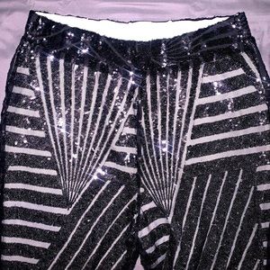 Black sequin flare leg pants super cute in excellent condition soft lighting.
